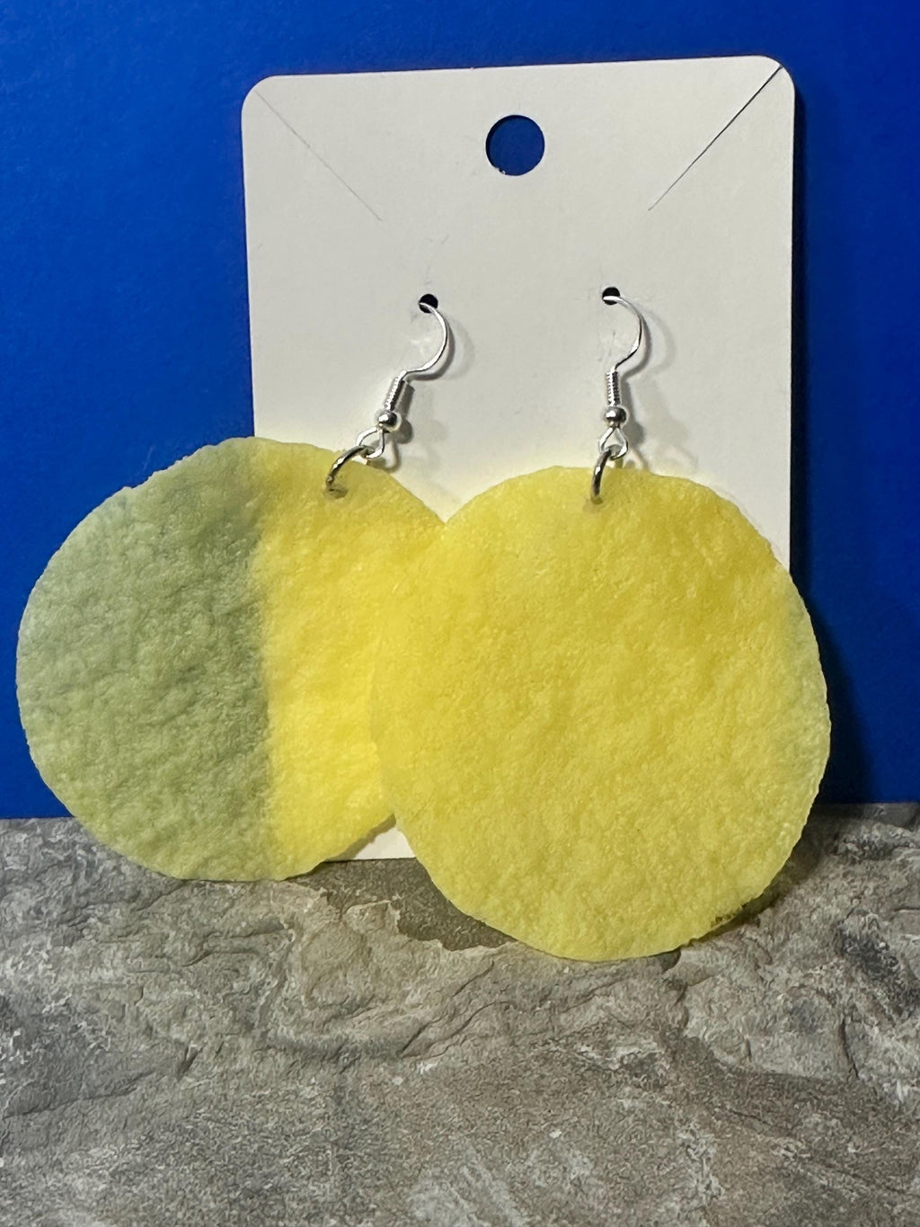 Smooth potato chip earrings on white card, close-up of chip texture