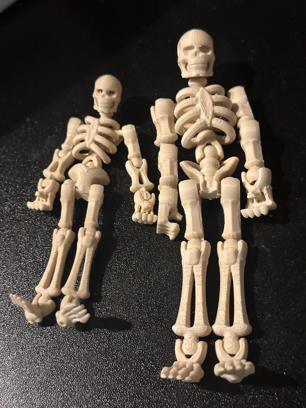 Skeleton buddy figure resting in black coffin, angled close-up