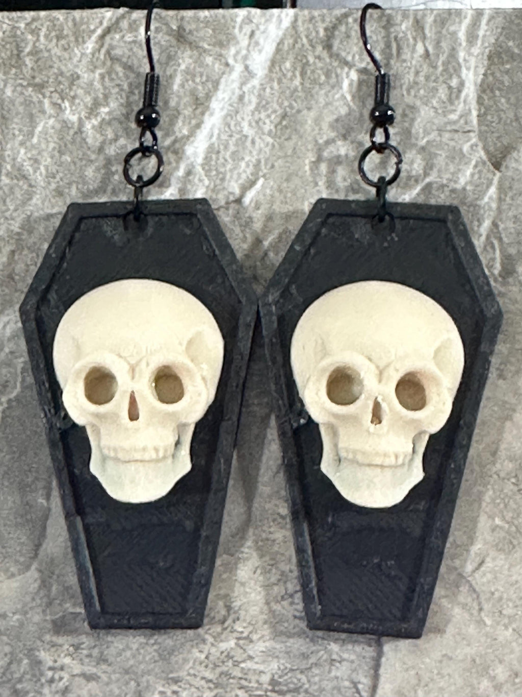 Close-up of gothic skull coffin earrings showing skull detail