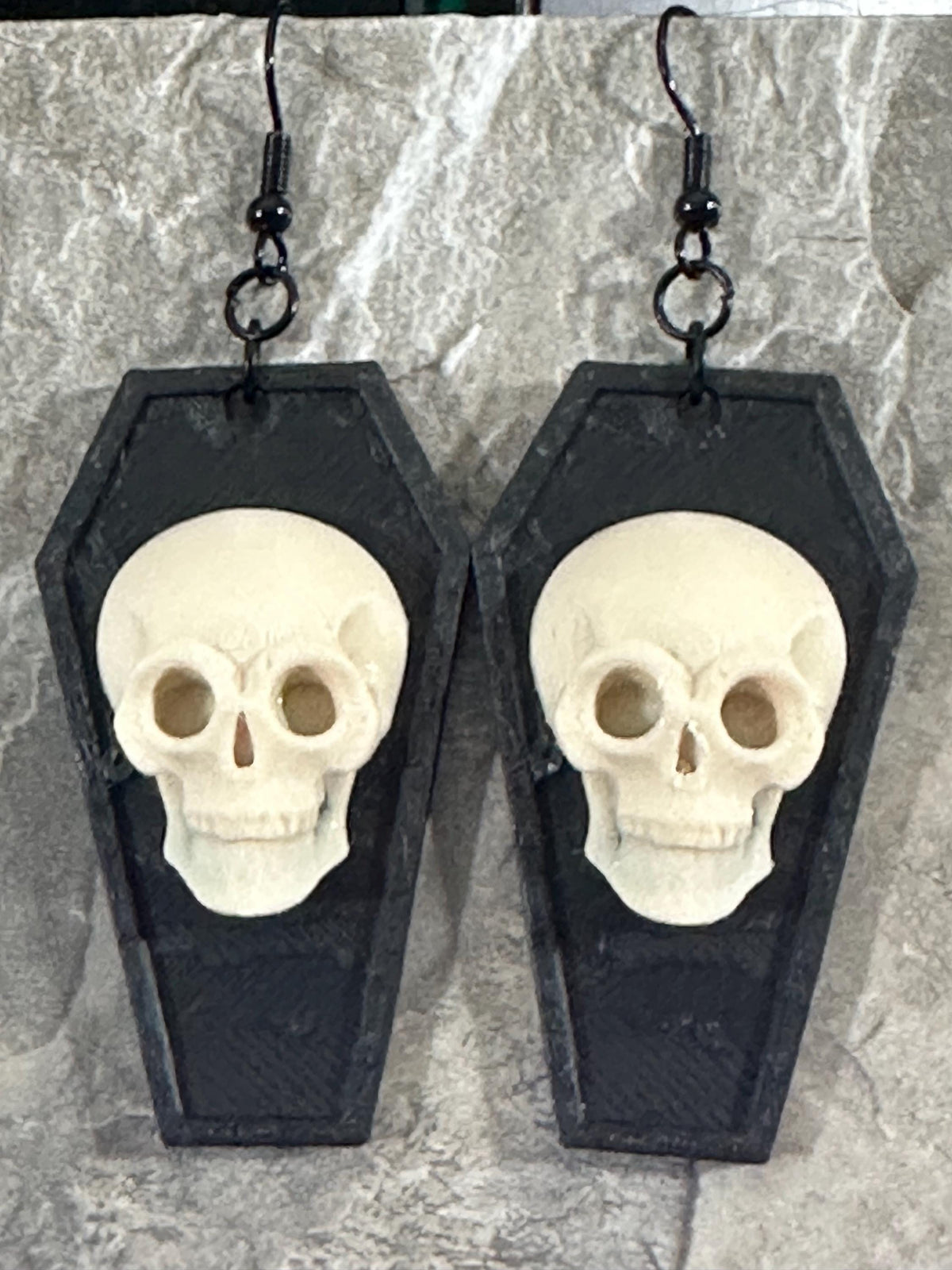 Close-up of gothic skull coffin earrings showing skull detail