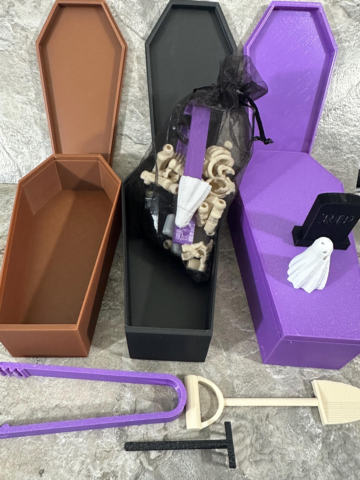 Open coffin boxes with mesh bag of skeleton bones, RIP tombstone and ghost