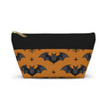 Black and orange bat print zip pouch with gold zipper pull, front view on white