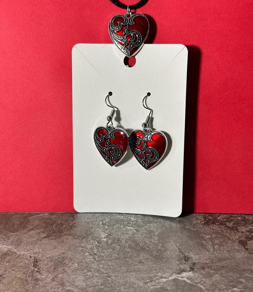 Red heart earrings on display card with matching heart pendant on black cord above