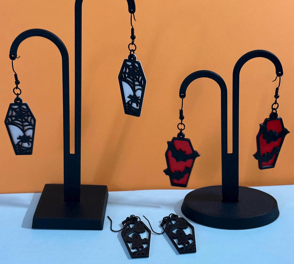 Halloween coffin earrings in spiderweb, bat and ghost styles on black display stands