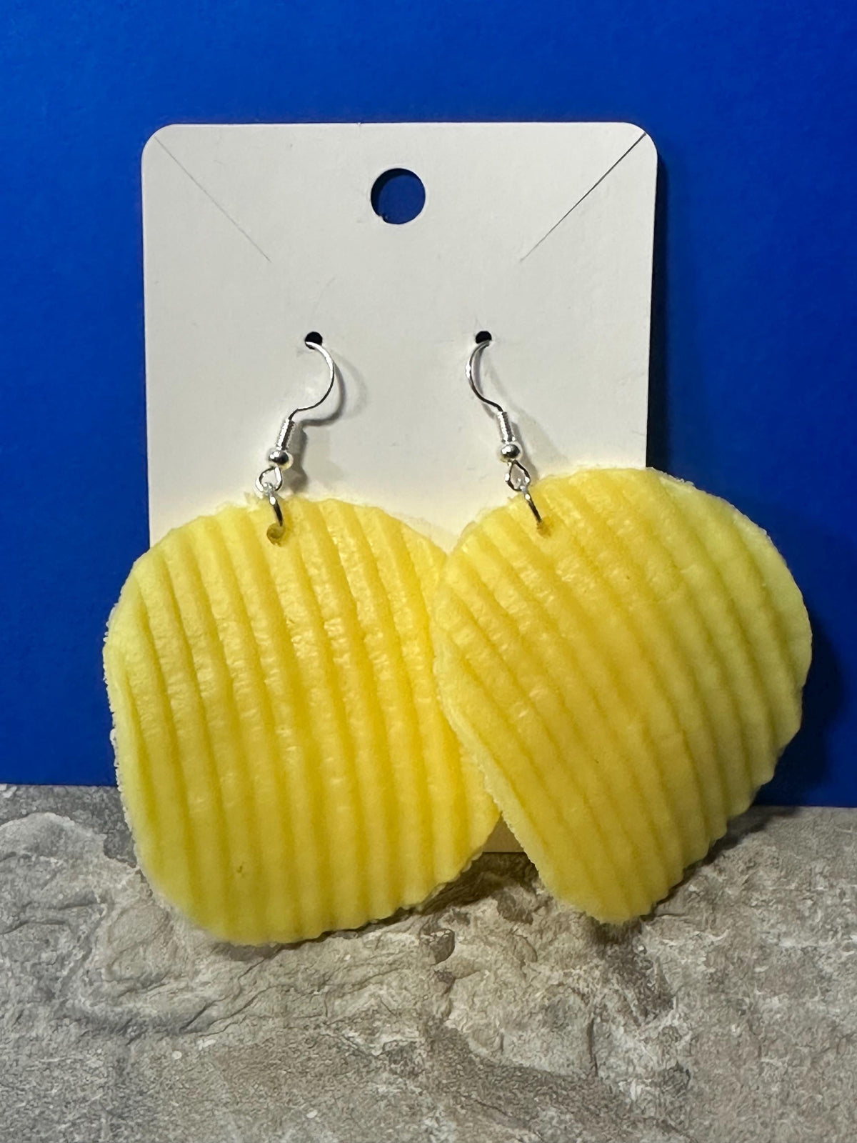 Ruffled potato chip dangle earrings on silver hooks, close-up on earring card